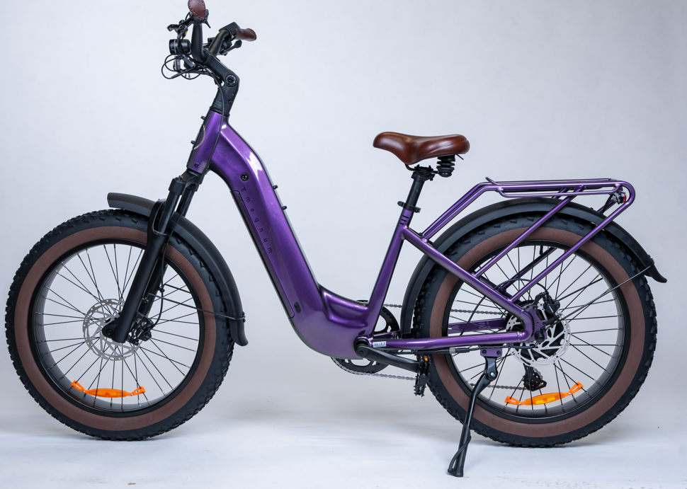 The Magnum - Bliss by Tampa Bay eBikes is a purple electric bike with wide tires, brown seat and grips, rear rack, and kickstand, featuring a powerful motor and shown against a plain white background.