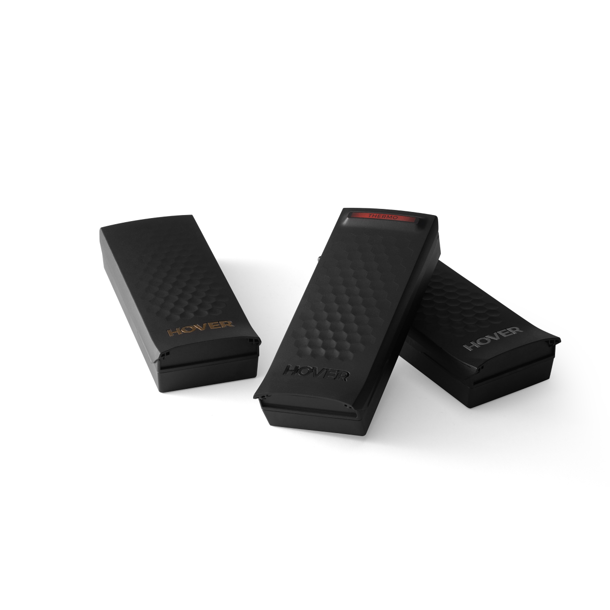 Three black textured pedal cases are diagonally arranged, each displaying "HOVER" logos, with the top one featuring a striking red label. Enhance your experience with the HOVERAir X1 Pro & Pro Max for extended flight time and smart battery efficiency.