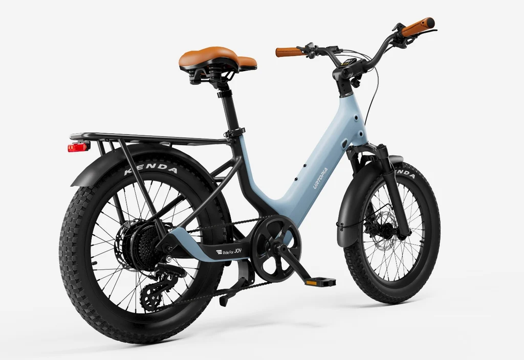 The Urtopia - Joy Carbon by Urtopia is a matte blue eBike with a brown seat and handlebars, carbon frame, rear rack, fat tires, front and rear fenders, shown against a plain white background.