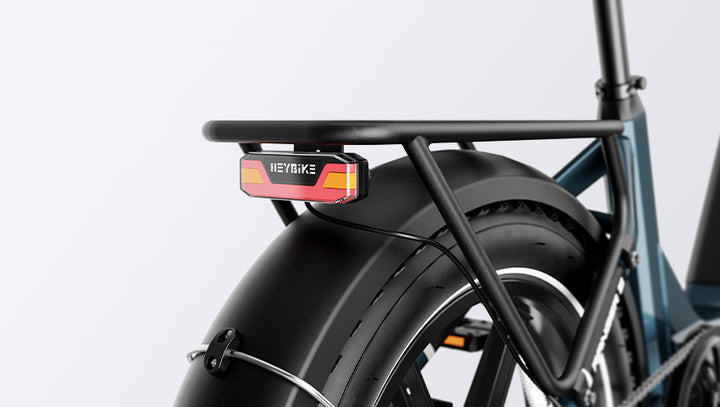 Rear view of a HeyBike- Ranger S electric bike showing a close-up of a modern, pink taillight mounted on a black rack over the rear wheel.