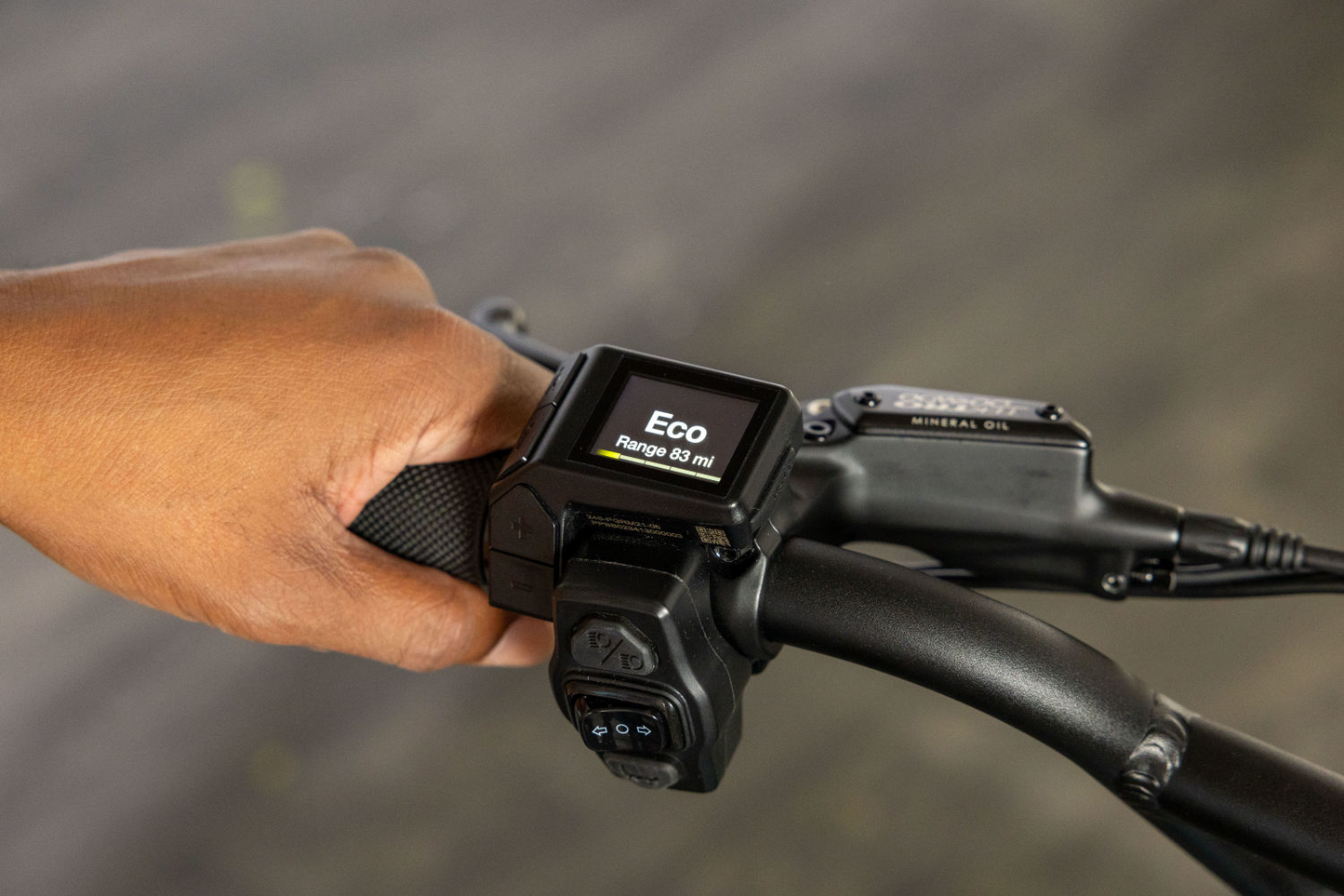 Close-up of a person's hand gripping a Momentum - Cito E+ handlebar with an "eco" control display showing the speed at 881 m.