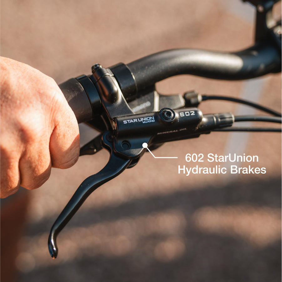 Close-up of a hand gripping a Lectric XP4 eBike handlebar, highlighting its 602 StarUnion Hydraulic Brakes.