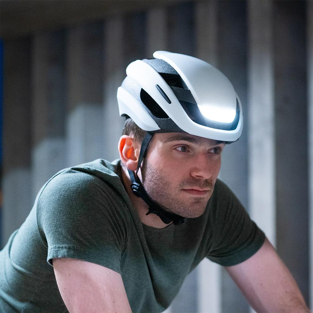 A focused cyclist wearing a Lumos Ultra MIPS Helmet.