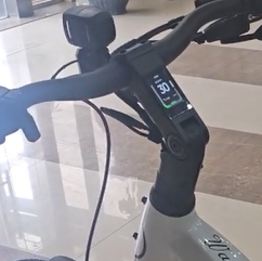 Close-up of the Magnum - Bliss electric scooter handlebar by Tampa Bay eBikes, showcasing a digital display with a speed of 30, emphasizing its powerful motor for smooth, efficient rides.