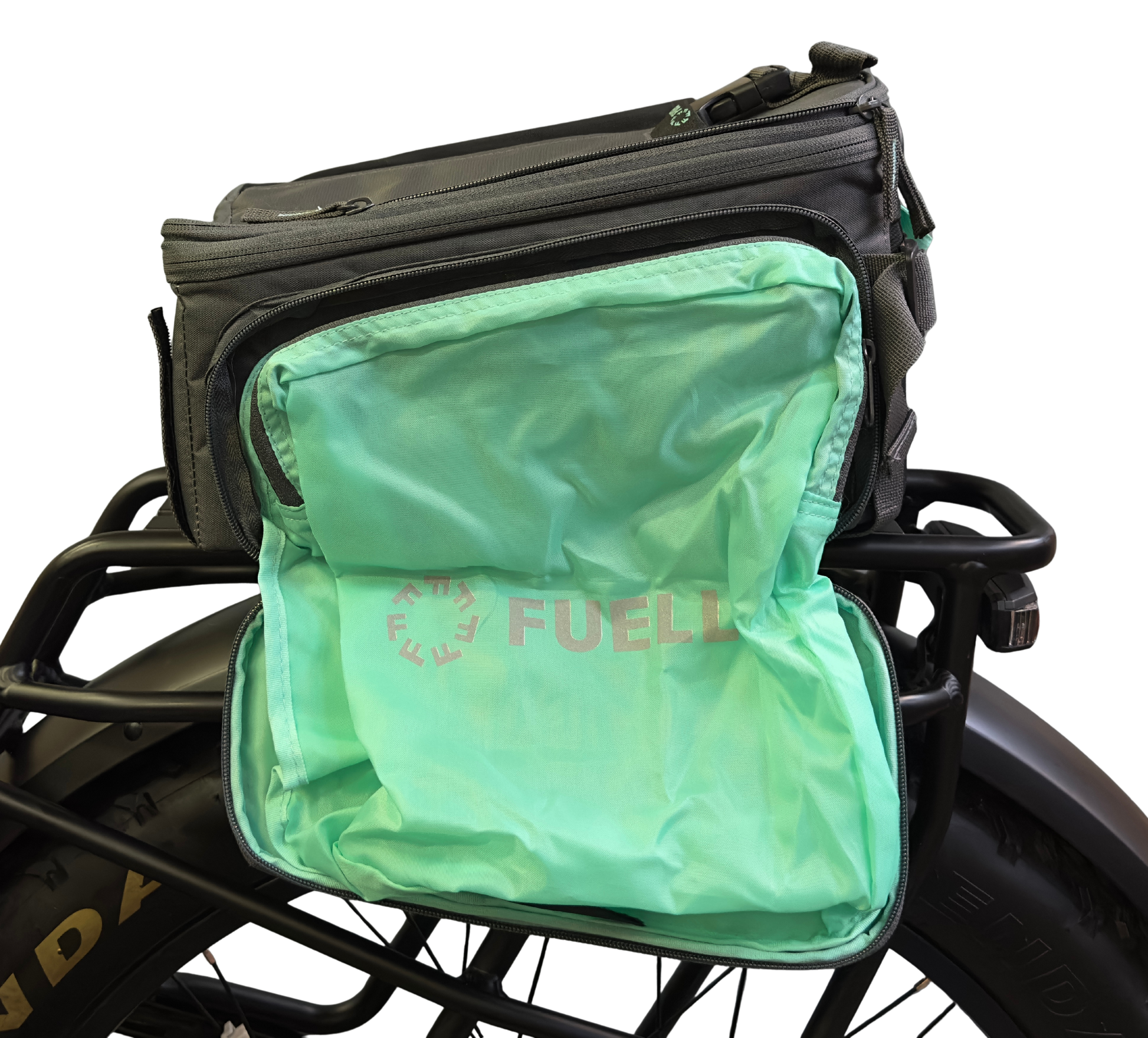 A Basil Sport Design MIK Bag in Graphite & Mint, shown unzipped on a bicycle rear rack to display its light green "FUEL" inner compartment. This e-bike bag uses Basil's secure MIK adapter system for easy attachment and removal.