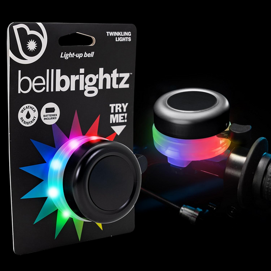 A packaged Brightz Bell Brightz, featuring vibrant multicolor LED lights, illuminates a bike handlebar against a black background.