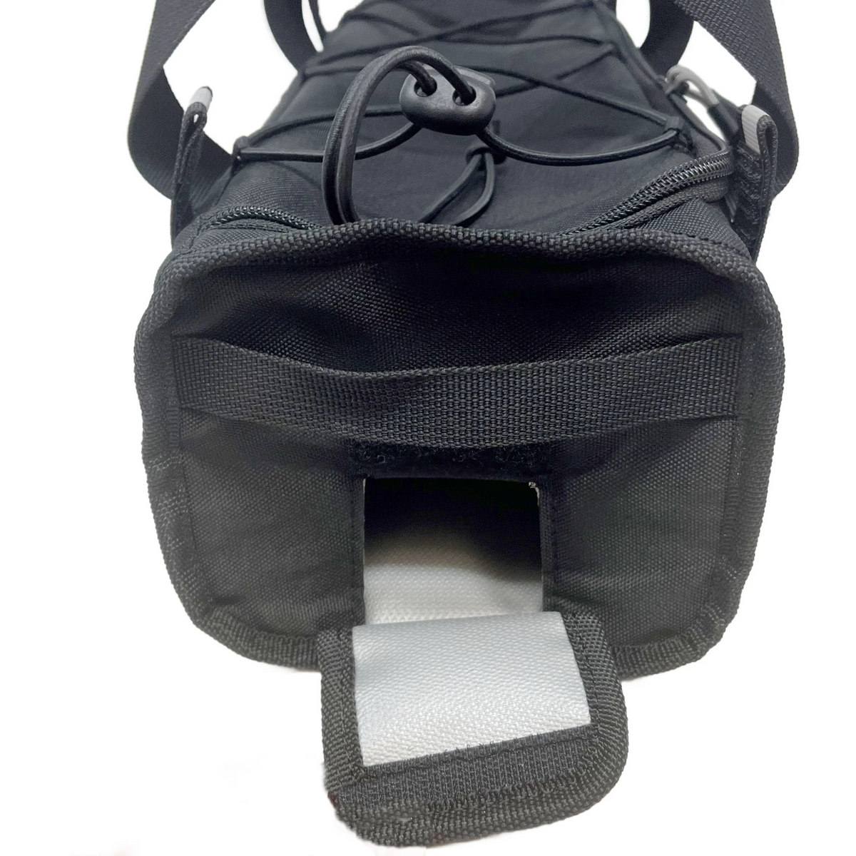 Close-up of the end of a black cylindrical BiKASE E-Bike Battery Rack Bag with a flap open, revealing a hook and loop fastener and a grey reflective strip inside the opening; compatible with Bosch Powertube batteries.
