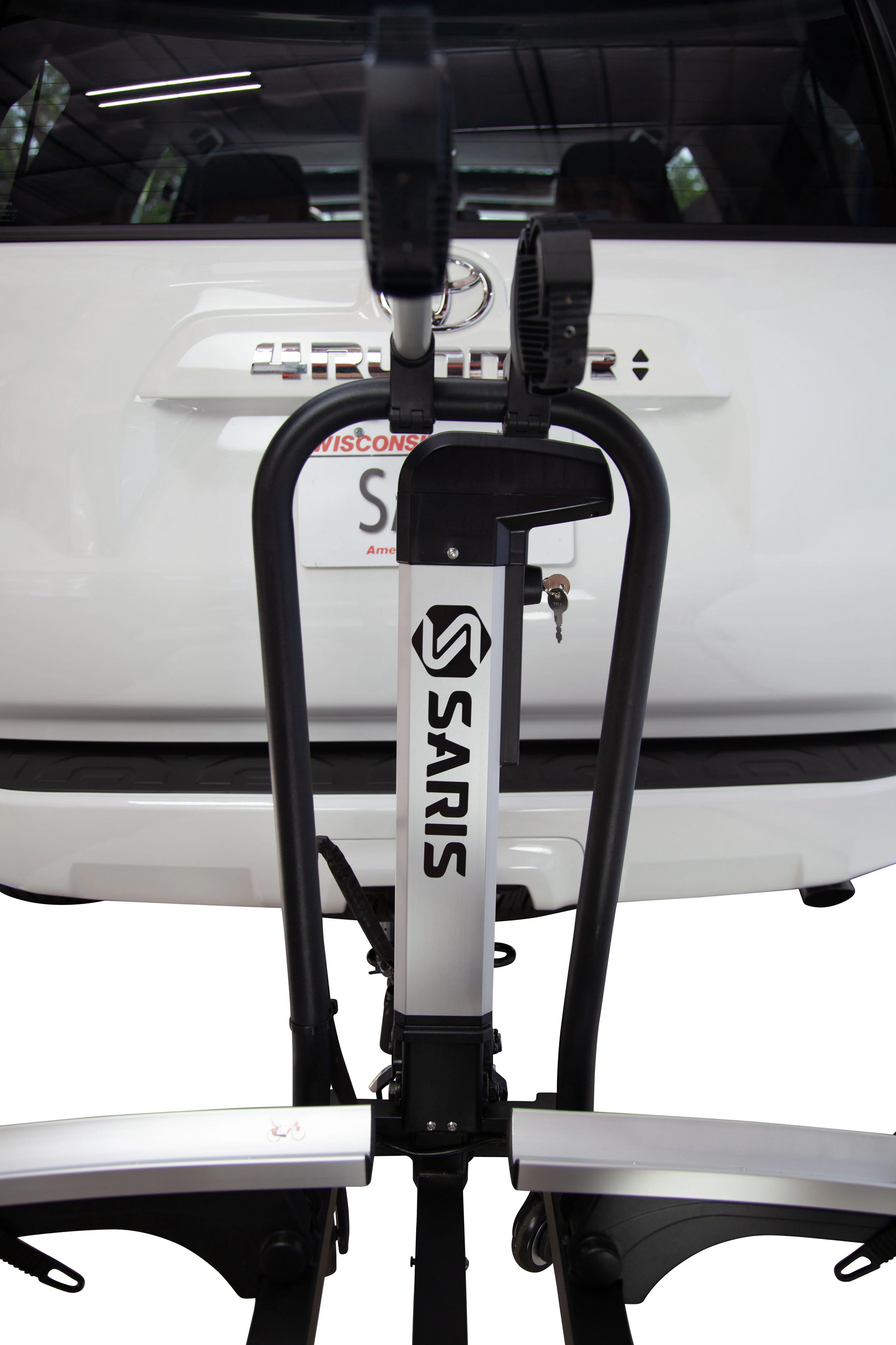 The Saris Door County 2-Bike Motorized Hitch Rack from Hollywood Racks is securely attached to the rear of a white vehicle, ensuring reliable eBike transport.