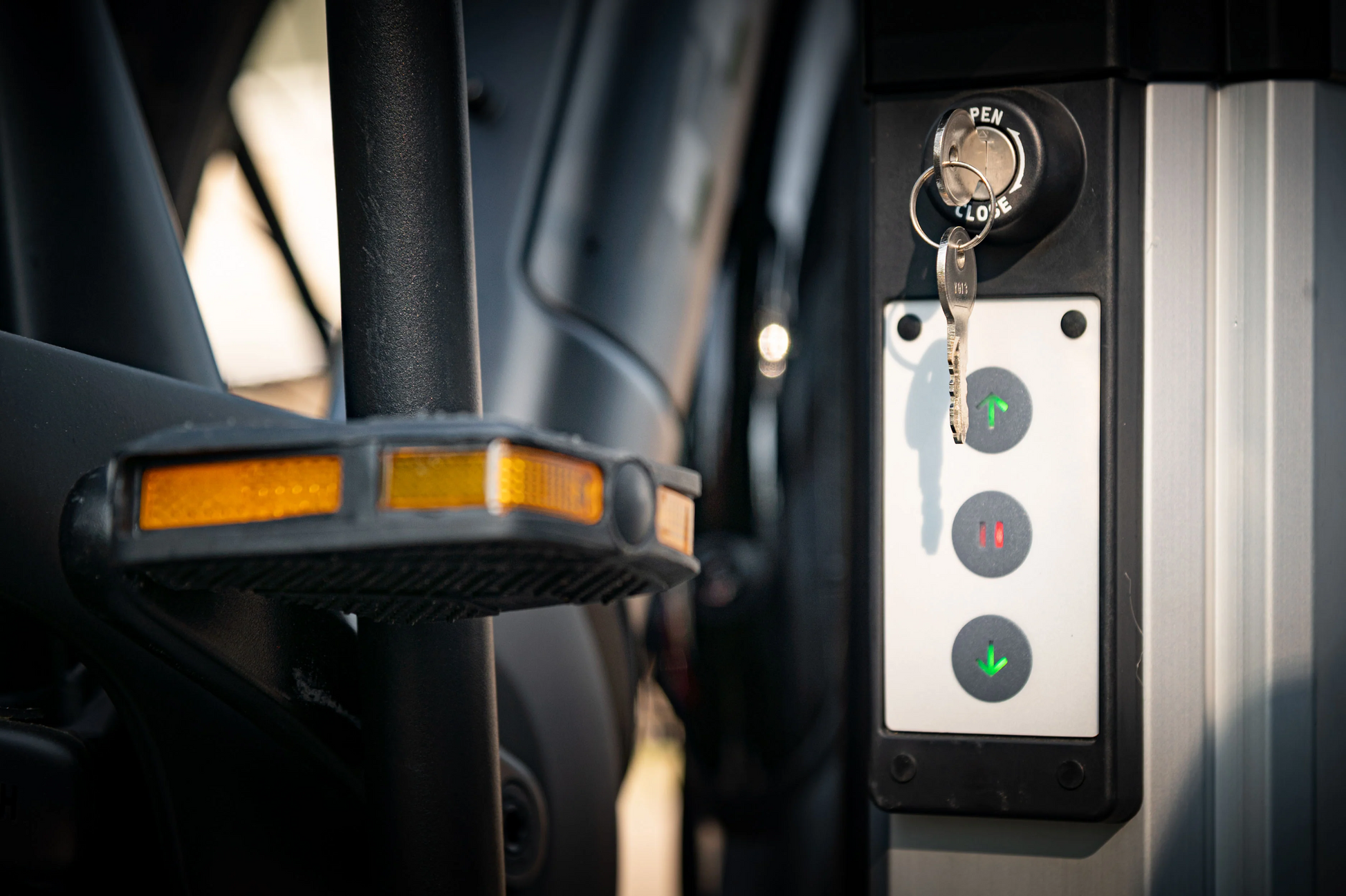 Close-up of the Saris Door County 2-Bike Motorized Hitch Rack by Hollywood Racks: features key ignition with buttons for stop, decrease, and increase functions—perfect for precise eBike management.