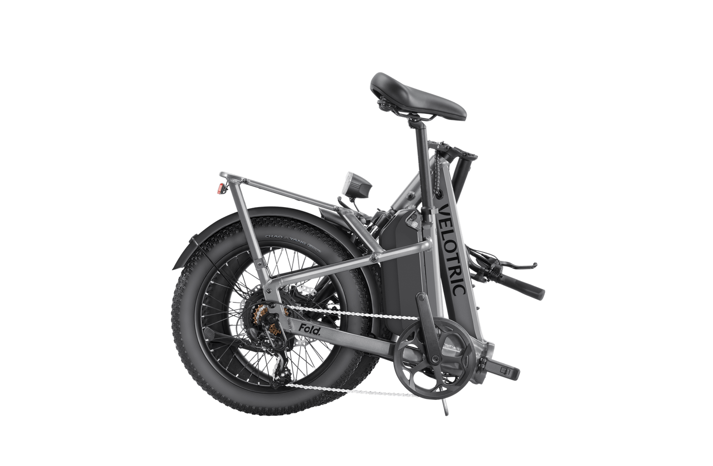A compact, folded Velotric - Fold 1 eBike with thick tires and a rear suspension, displayed against a solid grey background.