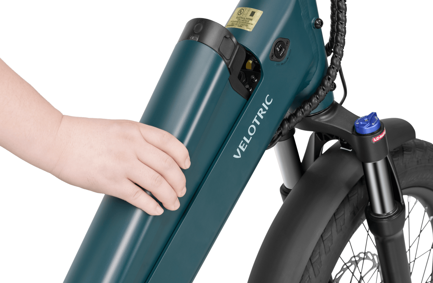 Close-up view of a person's hand inserted into a lock on the battery unit of a teal-colored Velotric Go 1 electric bike.