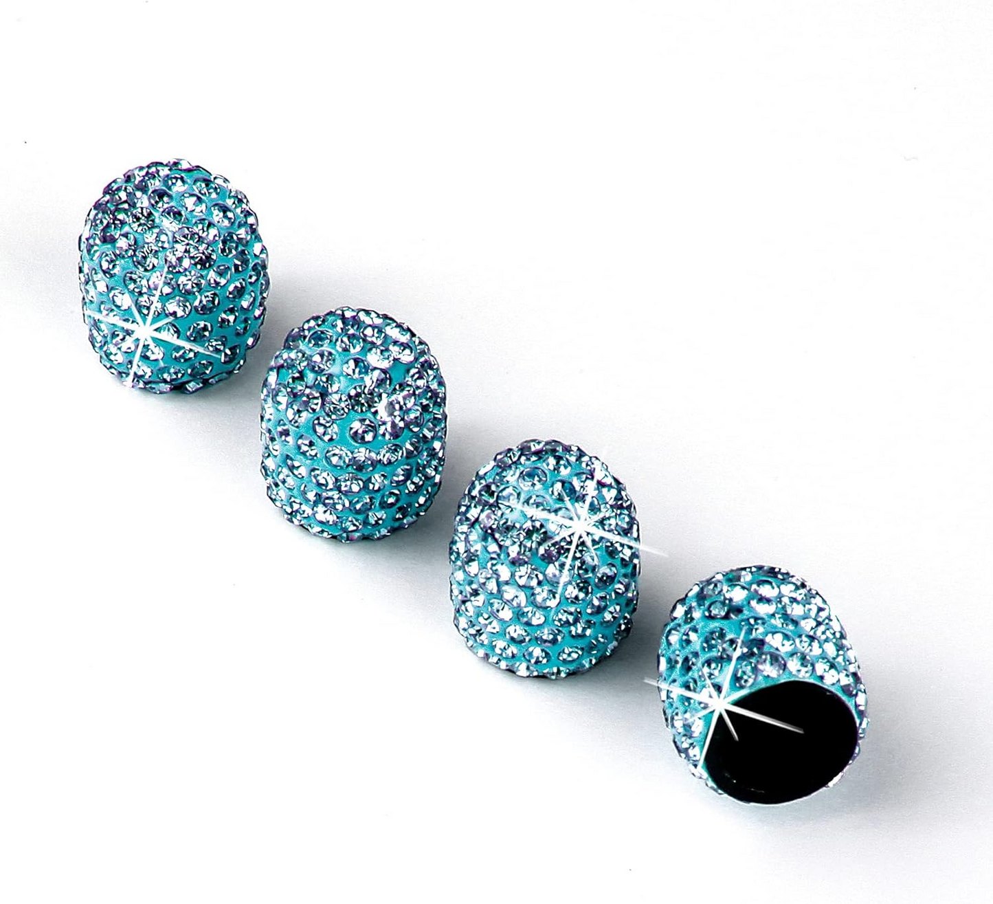Four EPWR Valve Gems - Aquamarine, sparkling blue and encrusted with crystals, are lined up on a white surface; one is open revealing its dark interior.