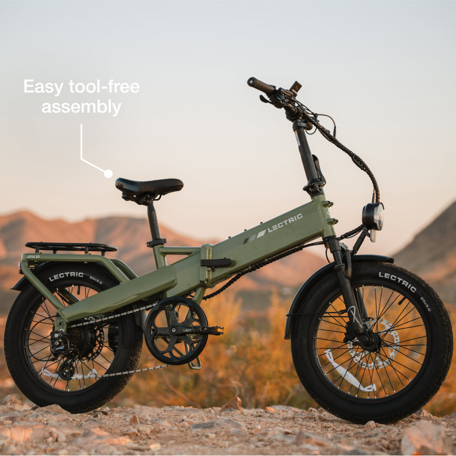 A green Lectric XP4 Folding eBike stands on dirt with mountains behind it; text reads "Easy tool-free assembly" and features its powerful 750W Rear Hub Motor.
