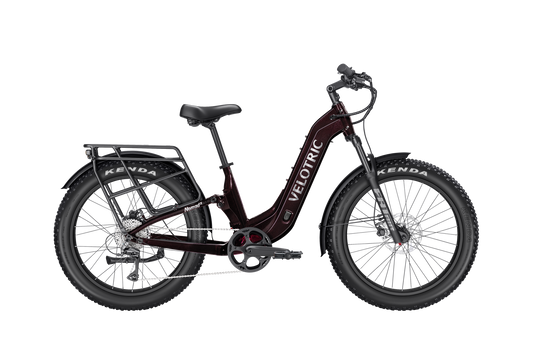 The Velotric Nomad 2X is a black step-through all-terrain eBike with wide tires, fenders, a rear cargo rack, and "Velotric" on the frame—ideal for adventure seekers.