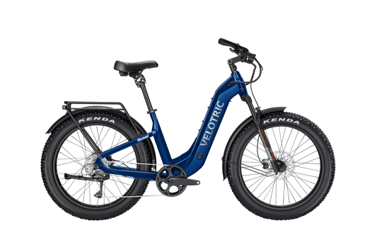 The Velotric - Nomad 2, ideal for adventure enthusiasts, features a vibrant blue step-through frame. Equipped with wide Kenda tires and all-terrain capabilities, it includes a high-capacity battery and a convenient rear rack for all your cycling trips.