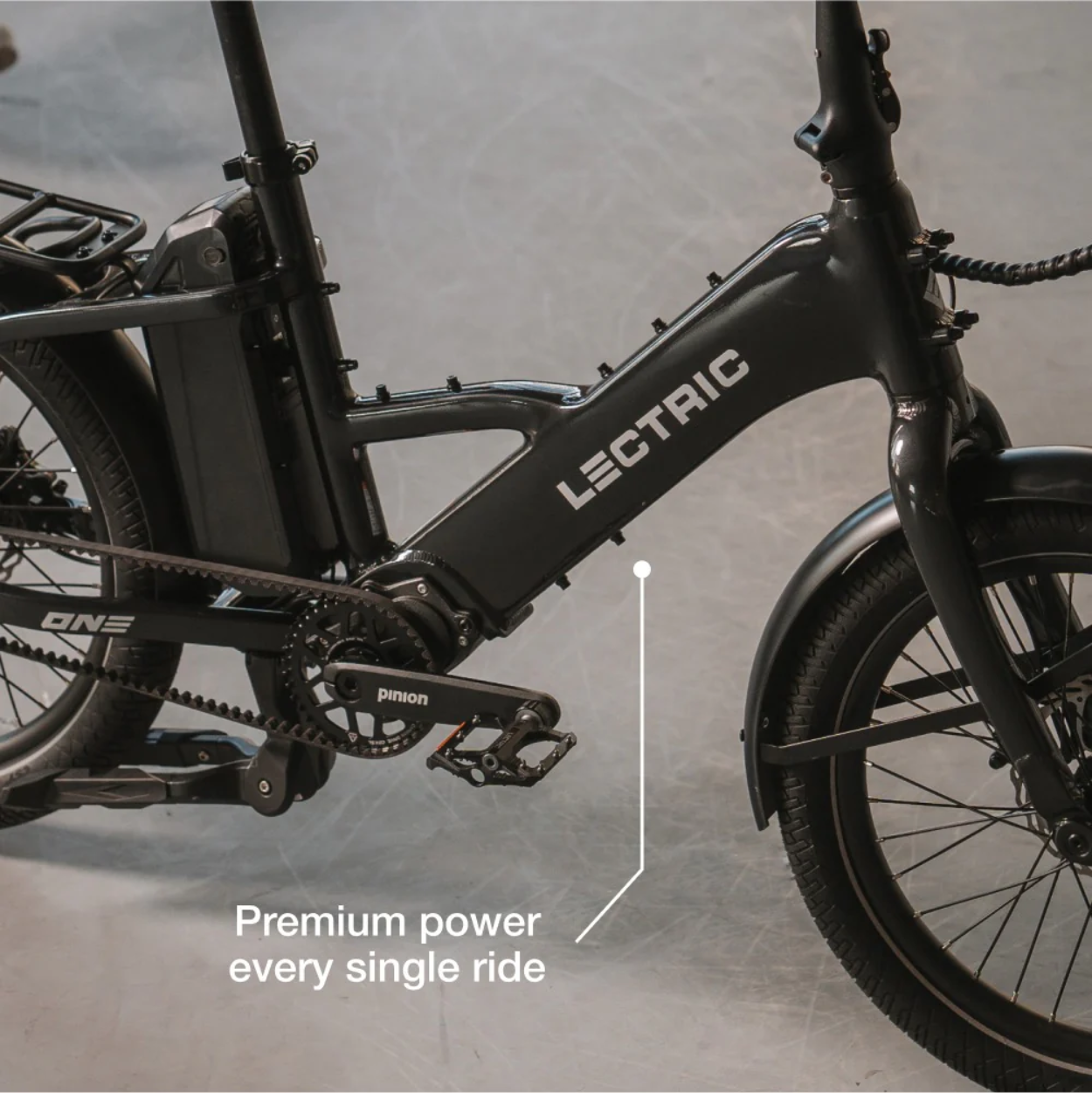 Close-up of a black Lectric - ONE electric bike showcasing the motor and pedal area, with text reading "Premium power every single ride.