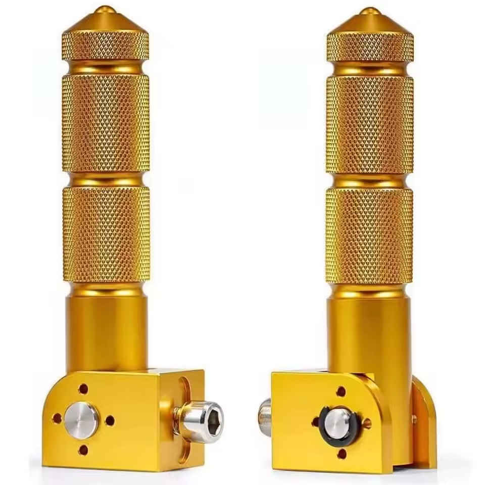 Two gold-colored, cylindrical metal Rear Pegs by Color Splash with textured surfaces and adjustable base screws, shown standing upright against a white background—resembling the precision engineering seen in high-quality eBike footrest components.