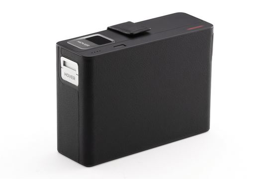 The HOVERAir Power Case features a sleek, black rectangular design with a textured surface and visible slider labeled "HOVER." With AI tracking, this 8K Flying Action Camera by HOVERAir is versatile and ready for any adventure.