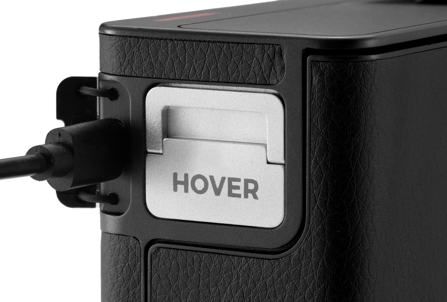 Close-up of a black HOVERAir device with a textured surface, featuring a silver panel labeled "HOVERAir Power Case" and a connected cable, showcasing OmniTerrain capabilities.