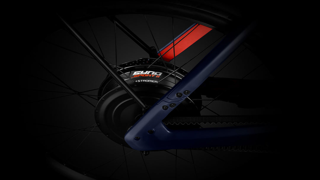 Close-up view of a black Stromer ST7 Alinghi Red Bull Racing Edition eBike's rear wheel hub and part of the frame, highlighting the brand "Stromer" on a dark background.