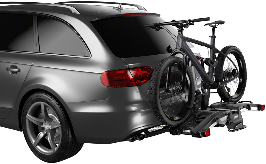 A gray car with a Thule EasyFold XT Hitch Bike Rack securely transports a black e-bike, ideal for hassle-free transport.