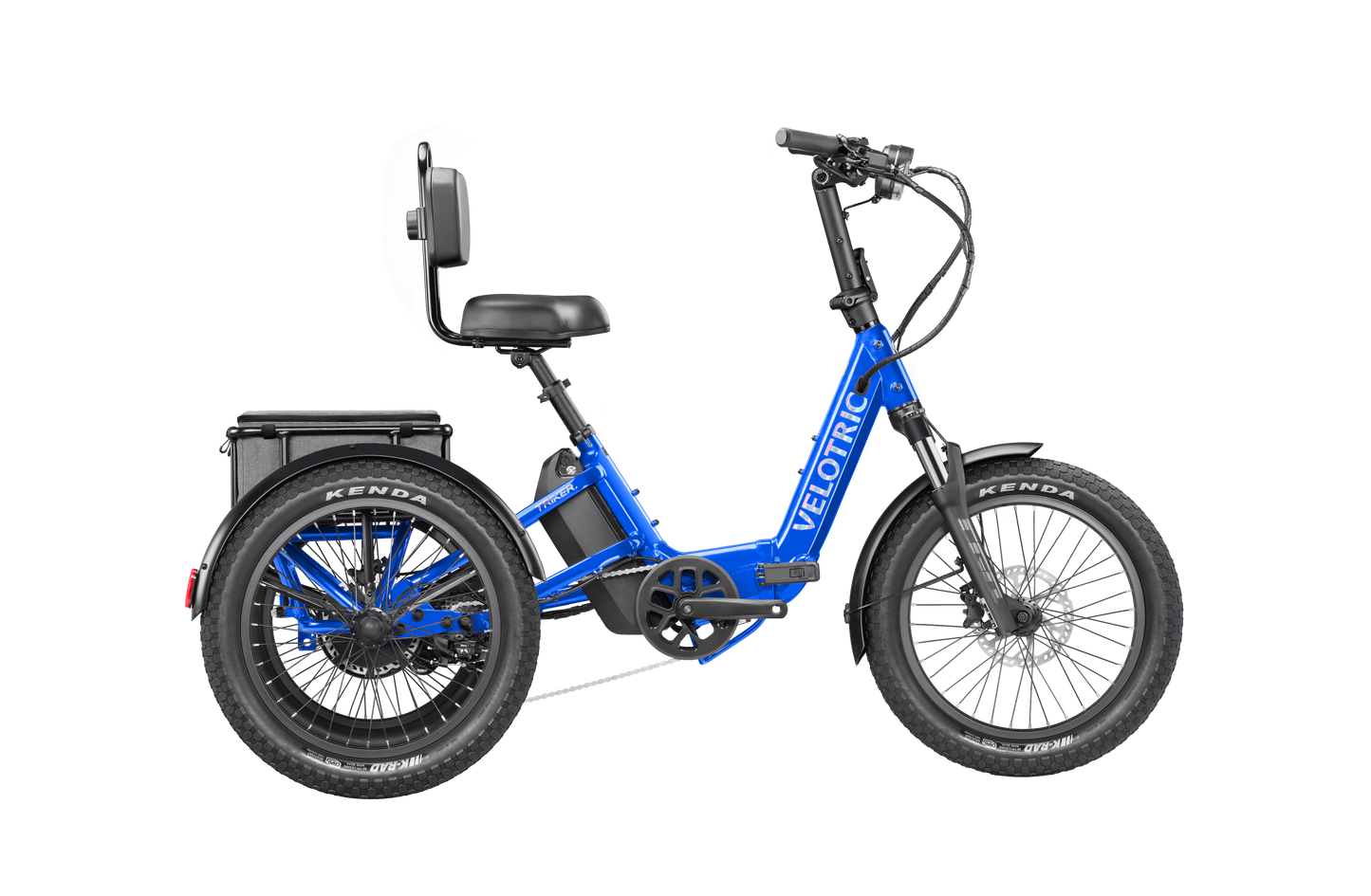 The Velotric Triker is a blue electric tricycle eBike featuring a 750W motor, backrest, wide seat, two rear wheels, thick Kenda tires, Shimano 8-speed drivetrain, and rear-mounted battery. The frame displays the Velotric brand name.