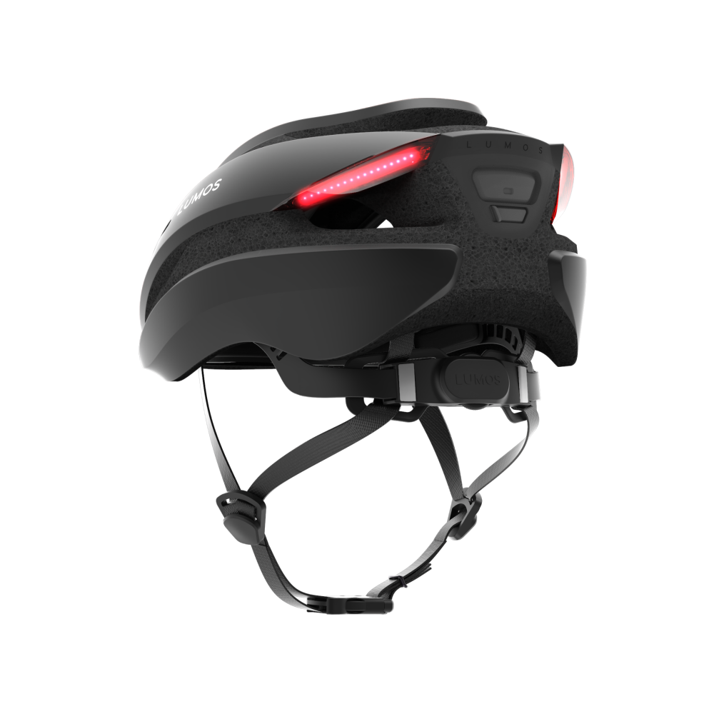 A Lumos Ultra MIPS Helmet with integrated LED lighting for cycling safety, featuring brake lights and turn signals on a black background.