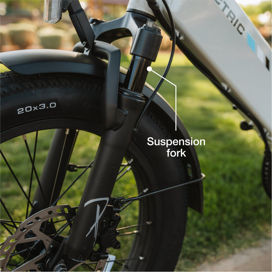 Close-up of the Lectric XP4 folding eBike's front wheel highlighting the suspension fork, tire, and brake disc, with a label indicating the suspension fork.