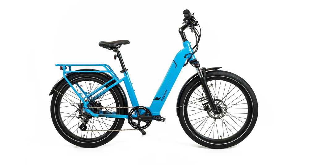 The Magnum Cosmo 2.0 T by Magnum is a blue e-bike with a low-step frame, front suspension, rear cargo rack, and wide tires, displayed in profile on a white background.