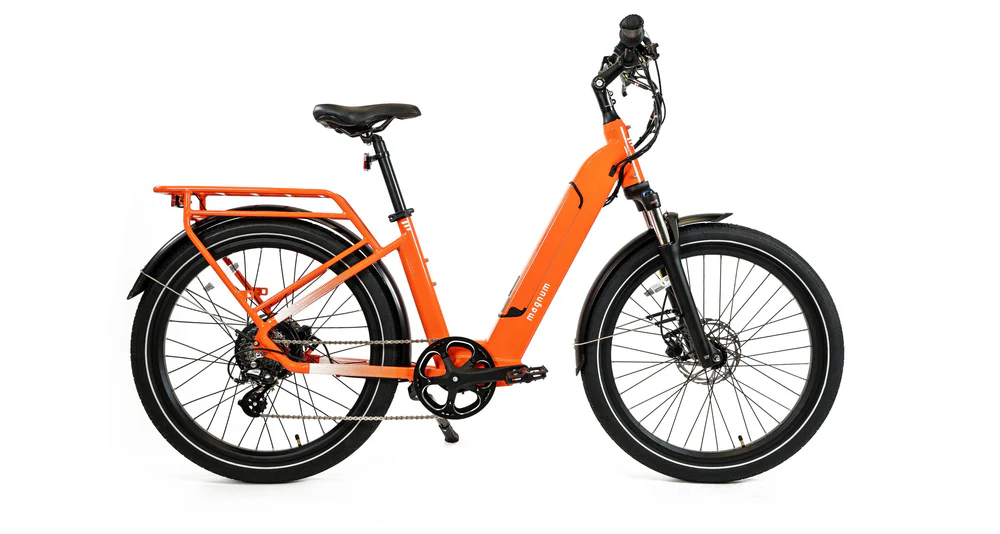 The Magnum Cosmo 2.0 T by Magnum is shown in a side view on a white background, featuring an orange low-step frame, rear cargo rack, front suspension fork, and thick black tires.