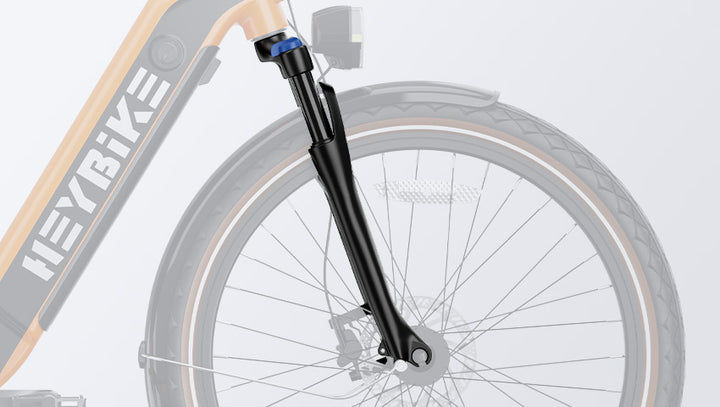 Close-up of a HeyBike Cityrun ebike's front wheel, featuring its hydraulic front suspension and disc brake, with a gray background.