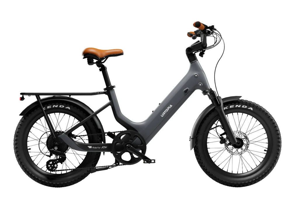 The Urtopia - Joy Carbon by Urtopia is a matte gray electric bicycle with thick tires, a rear cargo rack, disc brakes, a brown saddle, and a powerful 750W motor, shown from the side on a white background.