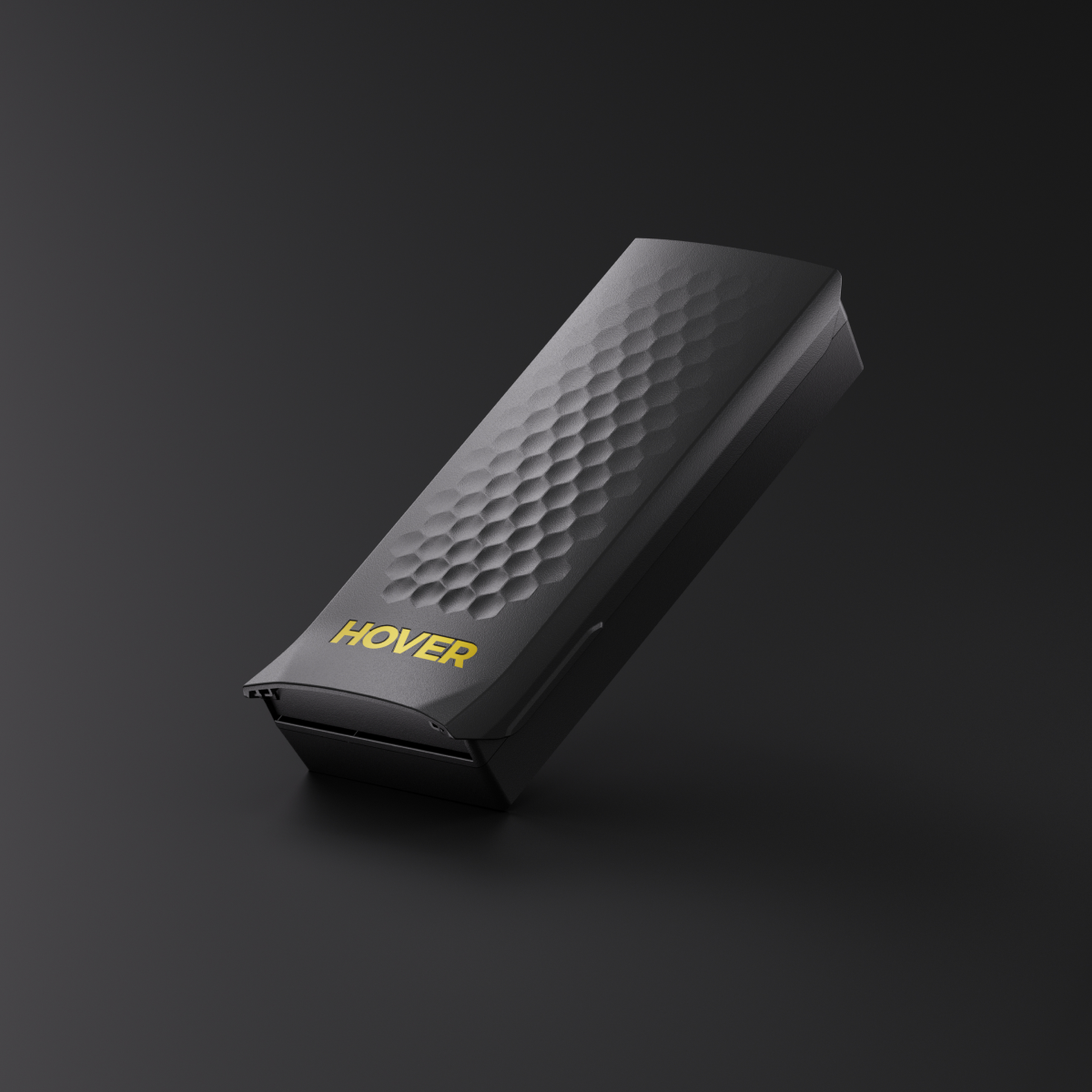 A sleek device in black with "HOVER" in yellow, featuring a textured honeycomb pattern similar to the HOVERAir X1 PRO Smart Battery, expertly designed for intelligent battery management and extended flight time, set against a dark background.
