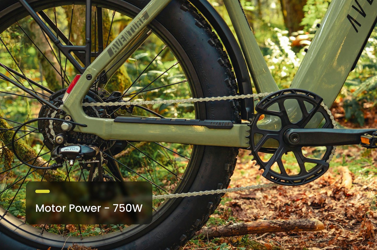 Close-up of the Aventon - Aventure 3 Fat Tire eBike’s rear wheel, gears, and chain on a forest trail. Overlay displays “Motor Power – 750W.” Model pictured: Aventon - Aventure 3 by Aventon.