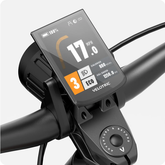A Velotric Summit 1 eBike computer showing speed, battery level, and other metrics mounted on handlebars.