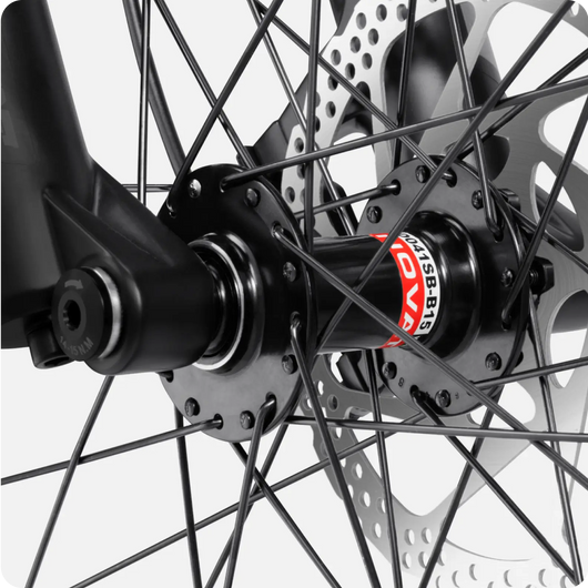 Close-up of a Velotric - Summit 1 eBike wheel hub and spokes with a focus on a black disc brake rotor and a detailed hub bearing labeled "kabsler".