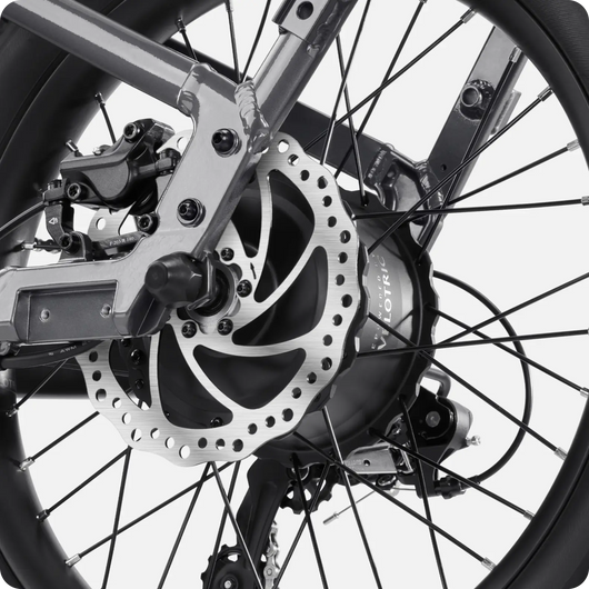 Close-up view of the Velotric - Fold 1's rear wheel and gear mechanism, showcasing the disc brake, derailleur, and sprocket.