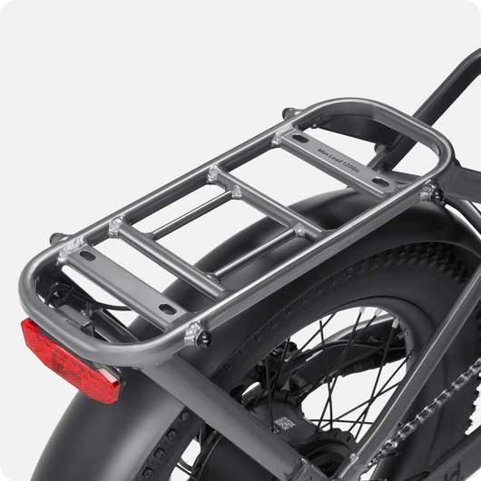 Close-up of a Velotric - Fold 1 motorcycle rear luggage rack over the rear wheel, featuring a brand logo that reads "Outback Mototek" on a foldable eBike.