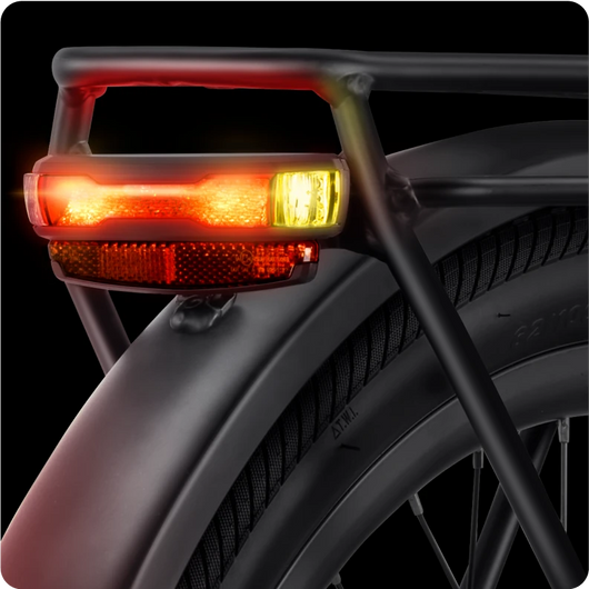 Close-up of the Velotric Discover 1's rear end, showing the tire, metal frame, and illuminated brake light with red and yellow lights. Perfect for Tampa Bay eBikes enthusiasts.