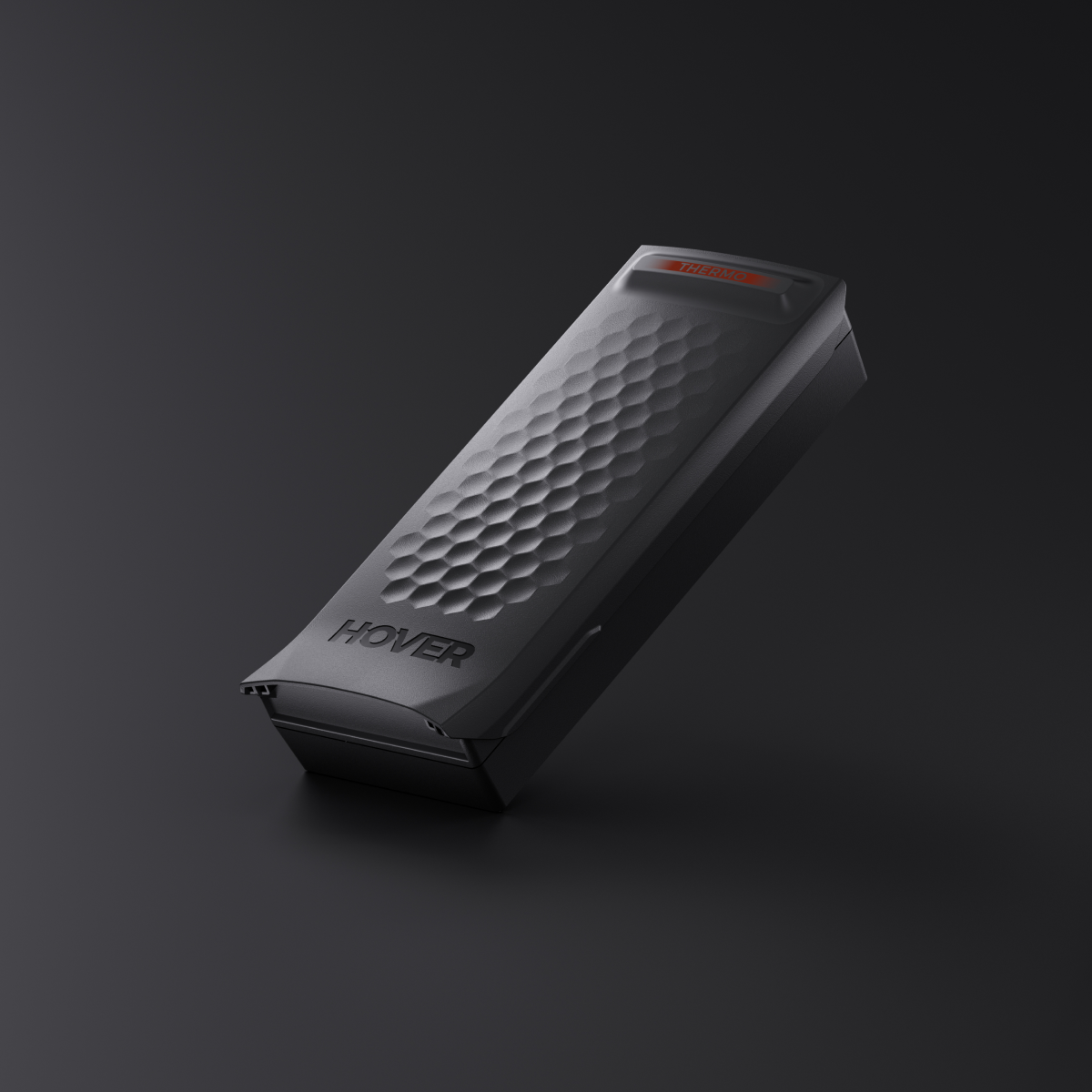 A black rectangular device labeled "HOVER" with a hexagonal surface pattern against a dark background, featuring the HOVERAir X1 PRO Smart Battery for extended flight time.