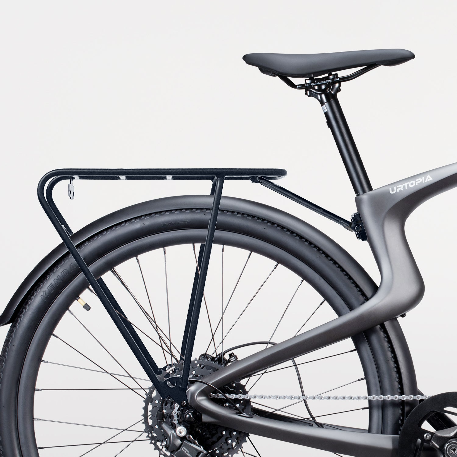 Close-up of the rear section of an Urtopia Carbon 1 Pro bike, showcasing a sleek design with lightweight construction, an integrated rear rack by Urtopia, and a large black tire against a white background.