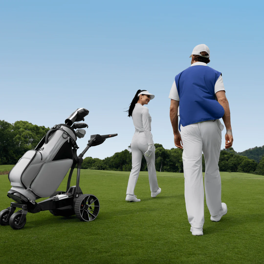 Two golfers walk on a Tampa Bay course near a Navee Birdie 3X electric golf push cart by Navee, under a clear blue sky.