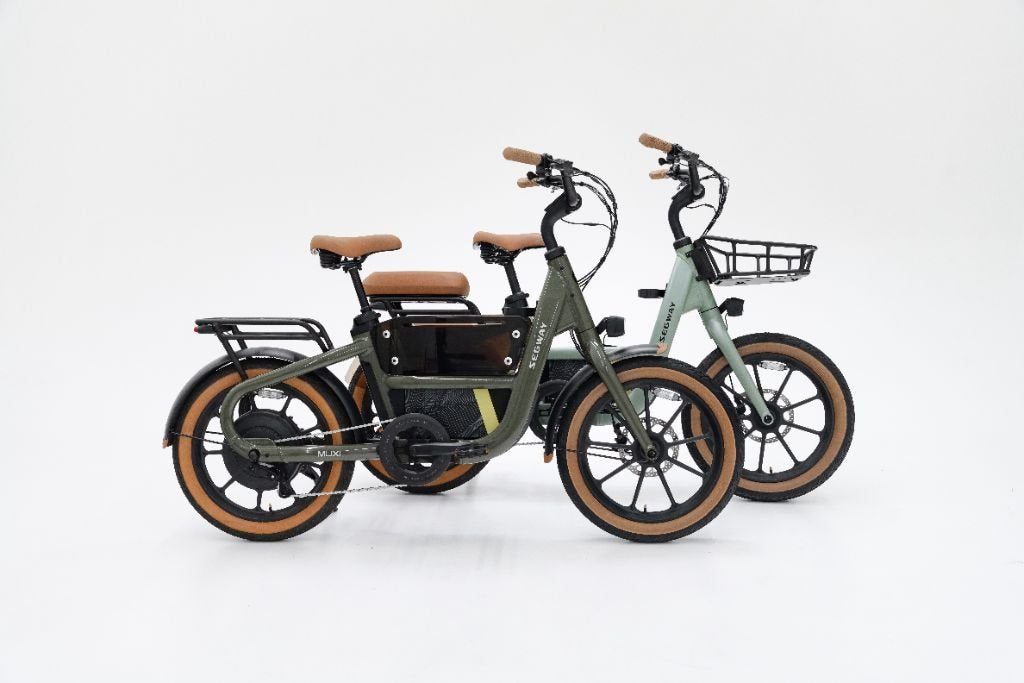 The Segway Muxi, a tan-tired electric bike with a 750W motor and rear rack, and a Segway family eBike with a front basket are displayed against a plain white background.