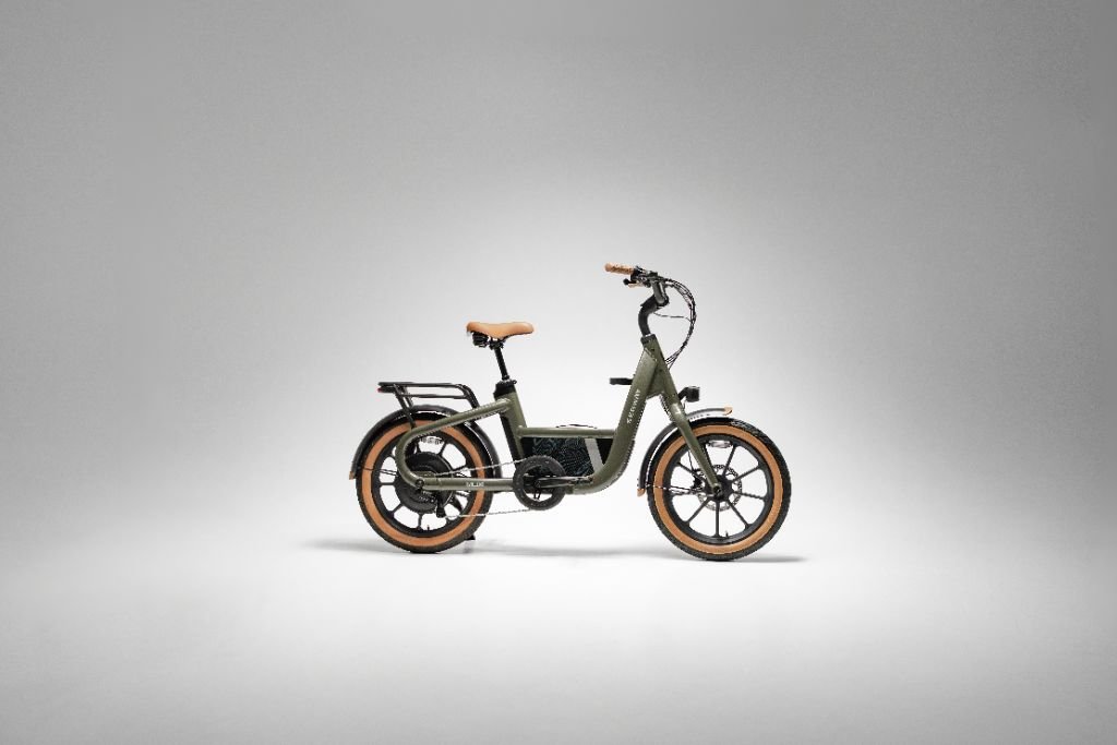 A Segway Muxi electric utility bike by Segway, featuring brown tires, a rear rack, and a step-through frame, is displayed against a plain gray background.