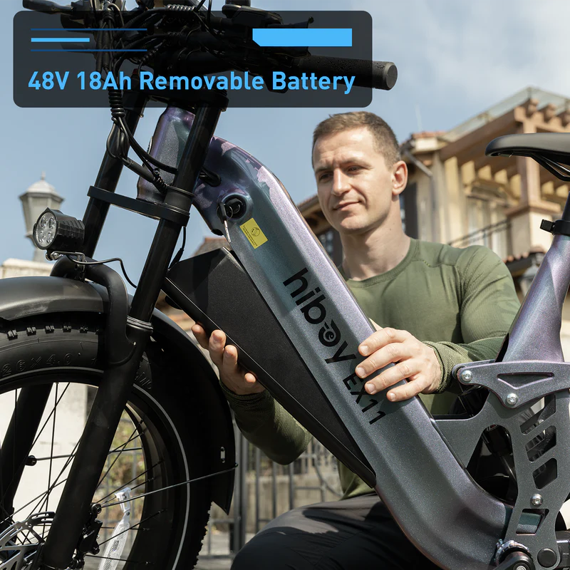 Outdoors, a man installs a removable 48V 18Ah battery into the Hiboy - EX11 full suspension electric bike by Hiboy.