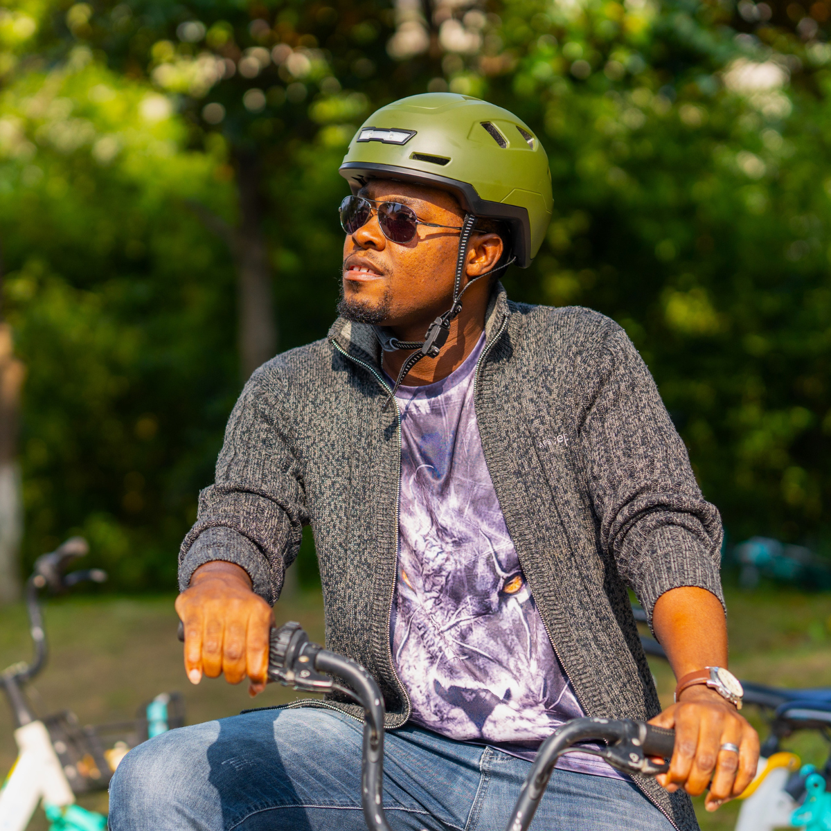 Man wearing a XNITO certified helmet riding a bicycle in a park.