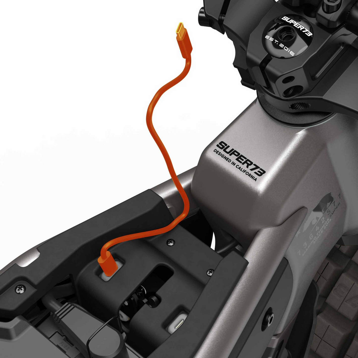 Close-up of a Super 73 - MZFT eBike frame with an orange charging cable plugged in near the seat and "Super 73" branding visible, emphasizing this iconic urban electric bike.
