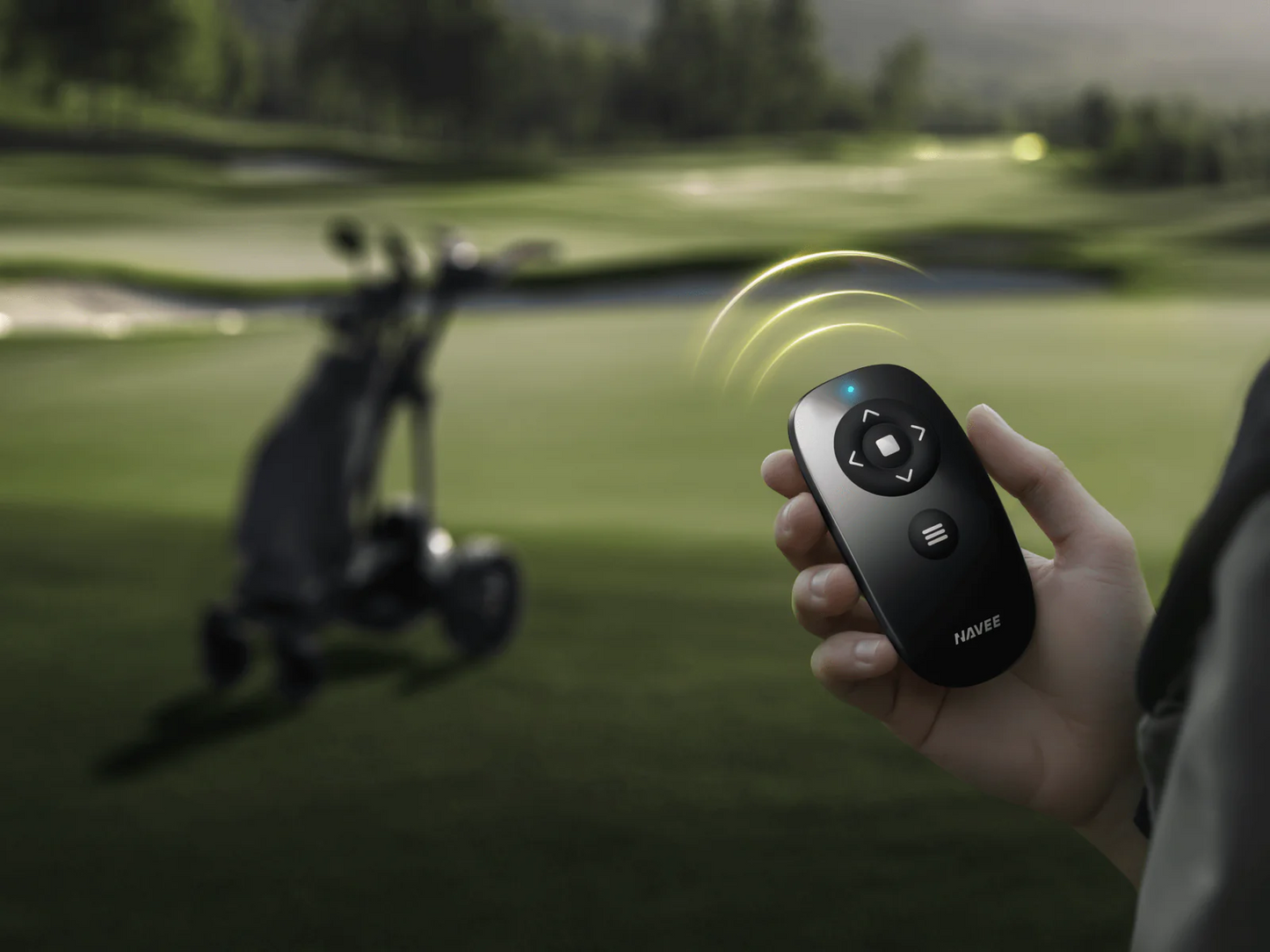 A person uses a Navee remote to control the Navee Birdie 3X auto-follow golf cart on a Tampa Bay course.