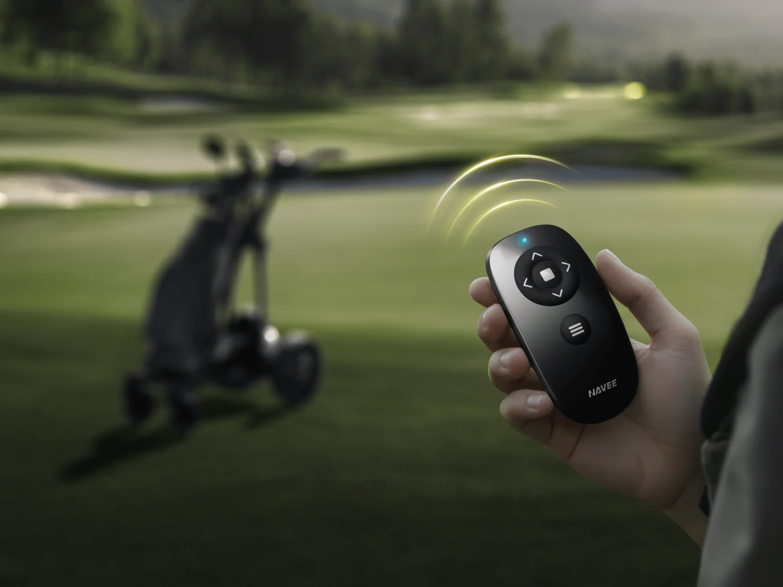 A person uses a Navee remote to control the Navee Birdie 3X auto-follow golf cart on a Tampa Bay course.