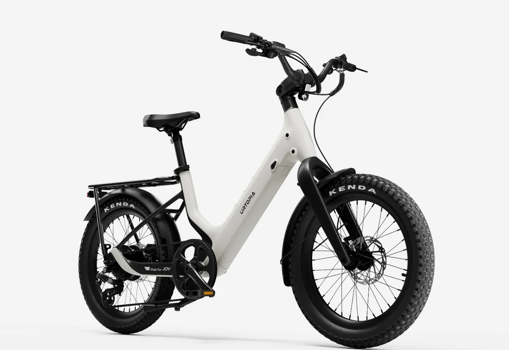 The Urtopia Carbon Joy Ultra by Urtopia is a white electric cruiser bike with fat tires, a step-through frame, rear cargo rack, and black accents, displayed against a plain white background.
